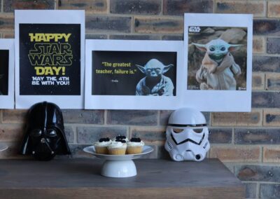 Star Wars-themed toys and sweets displayed on a table for Star Wars Day at the Surtech office