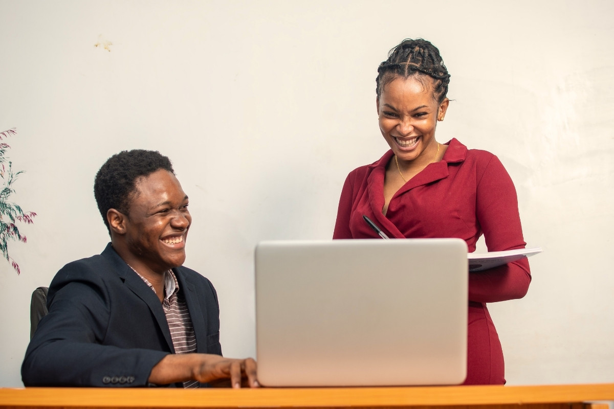 AI policy template 2 legal professionals smile widely as they engage in a cooperative and excited chat, having all the tools needed to implement an AI policy.